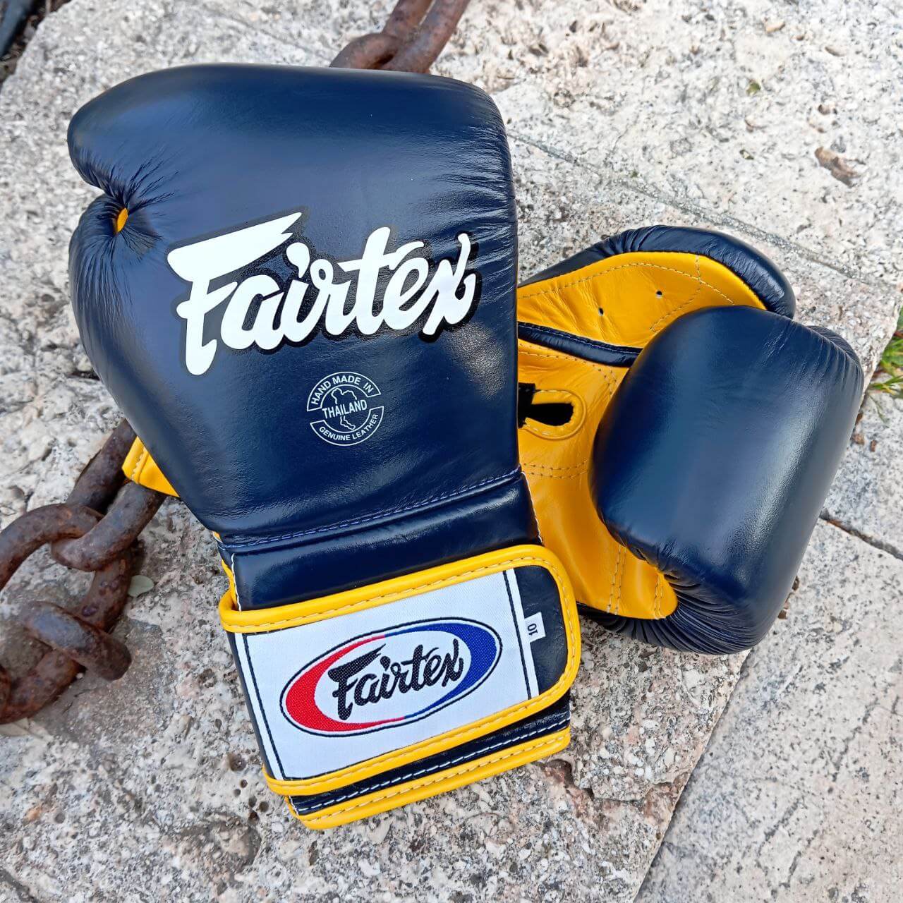 Guantoni Fairtex Mexican Style Heavy Hitter in pelle di vacchetta Blu/Giallo. Polso più lungo per una migliore stabilità dell'articolazione, imbottitura extra protettiva in triplo strato. Fodera interna Anti sudore per preservare l'imbottitura. Adatti a tutti i praticanti di Muay Thai, Boxe e Kickboxing.