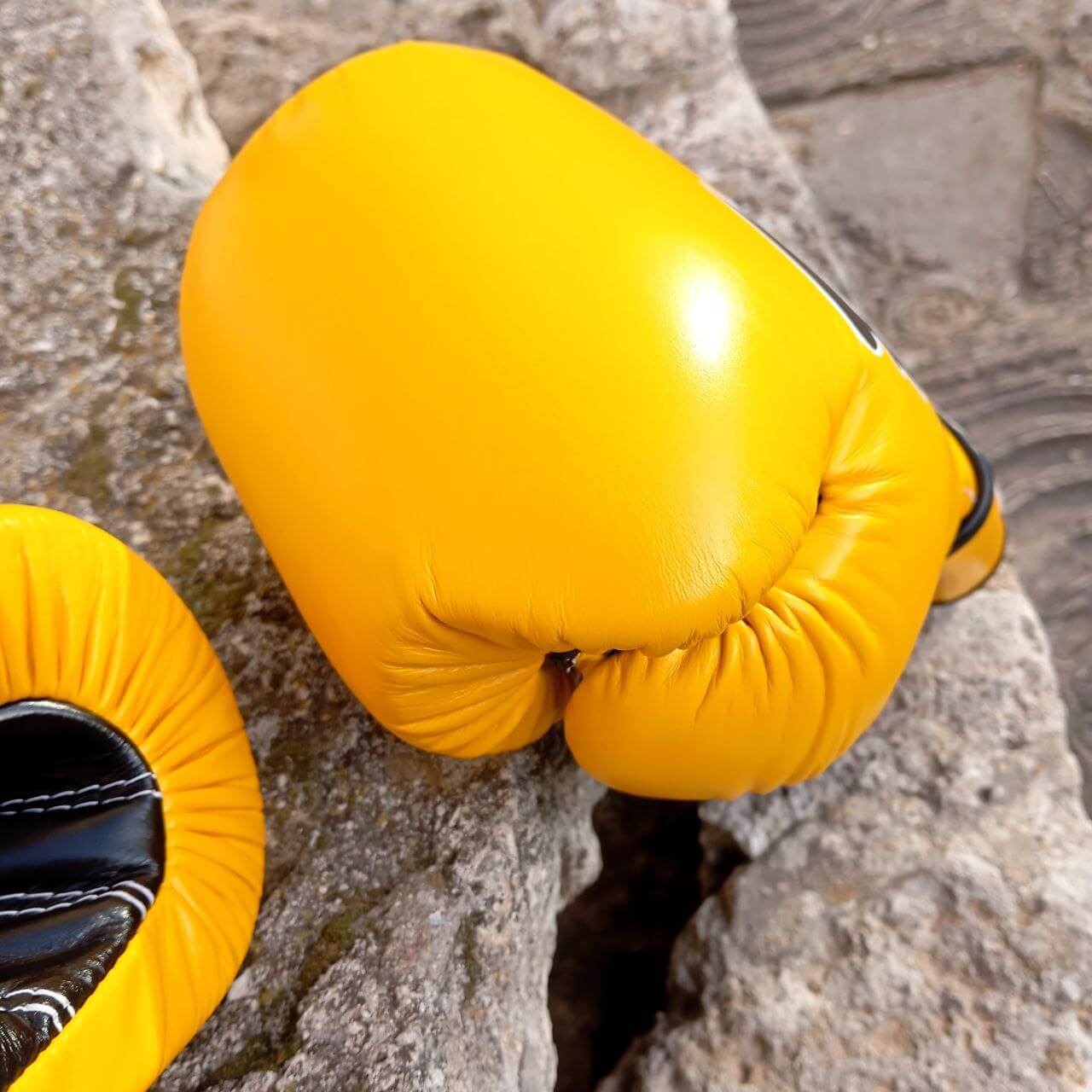 Guantoni Fairtex Mexican Style Heavy Hitter in pelle di vacchetta Giallo. Polso più lungo per una migliore stabilità dell'articolazione, imbottitura extra protettiva in triplo strato. Fodera interna Anti sudore per preservare l'imbottitura. Adatti a tutti i praticanti di Muay Thai, Boxe e Kickboxing.