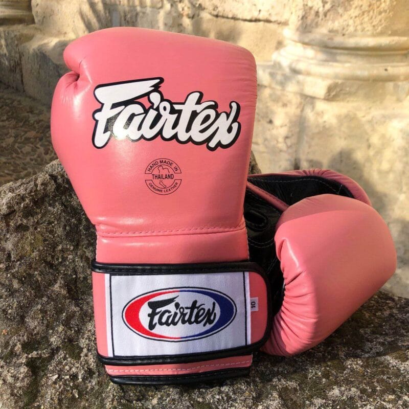Guantoni Fairtex Mexican Style Heavy Hitter in pelle di vacchetta Rosa/Nero. Polso più lungo per una migliore stabilità dell'articolazione, imbottitura extra protettiva in triplo strato. Fodera interna Anti sudore per preservare l'imbottitura. Adatti a tutti i praticanti di Muay Thai, Boxe e Kickboxing.