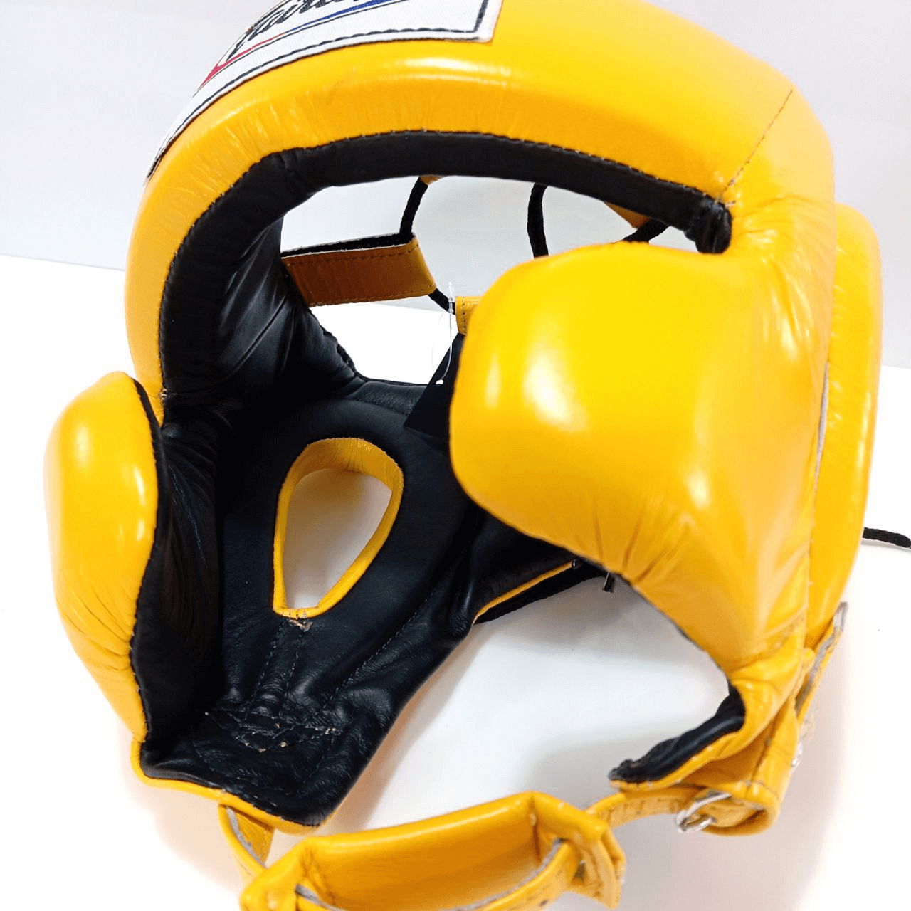 Caschetto Sparring Fairtex Mexican Style Giallo con Parazigomi, senza paramento, per allenamenti di Pugilato, Muay Thai, Kickboxing ed MMA. Dotato di imbottitura extra sulle zone d'impatto come zigomi, fronte ed orecchie, è realizzati con la migliore pelle bovina sul mercato per una durata senza eguali.