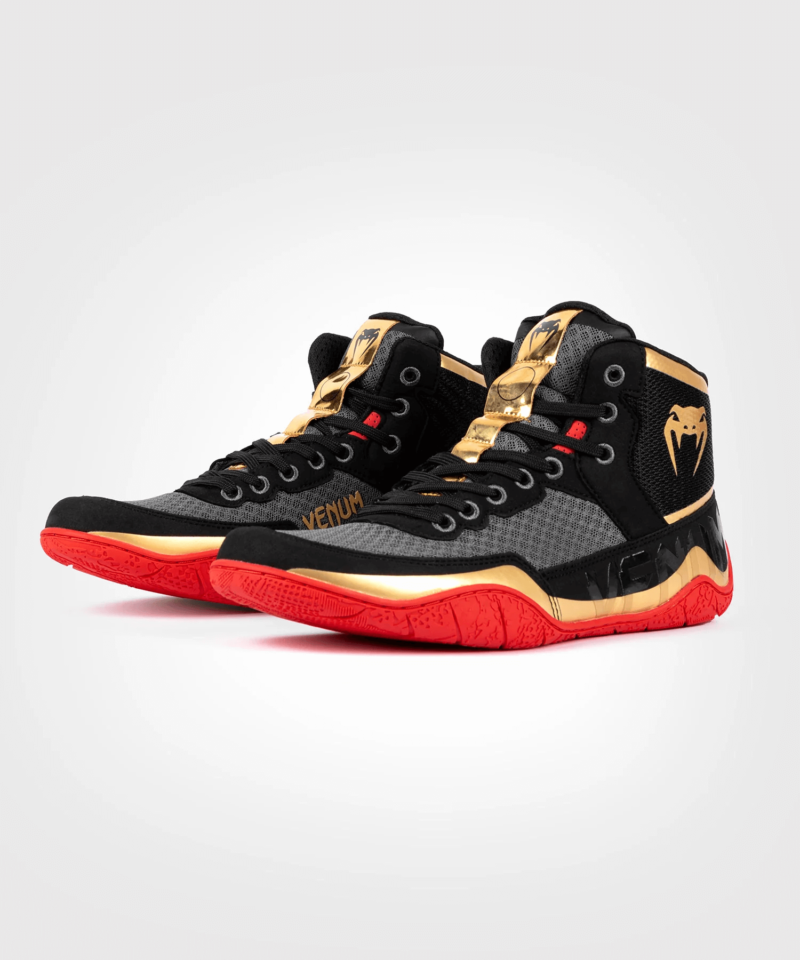 Scarpe da Lotta/Pugilato/Wrestling Venum Elite Nero/Oro/Rosso per allenamenti e gare di lotta e Boxe. Leggera, flessibile, morbida e comoda, è adatta ad entrambe le discipline. Scarpa bassa ideata per il massimo comfort e grip.