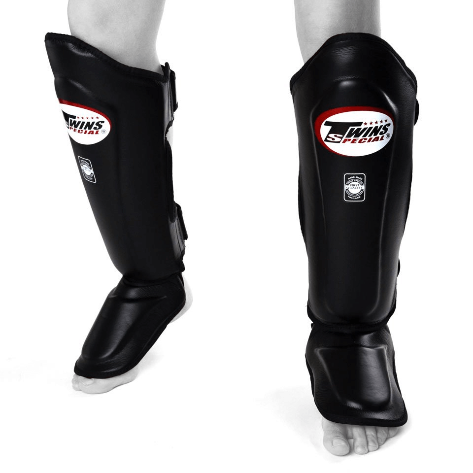 Paratibie Muay Thai Twins Special SGL10-BLK Nero in pelle per allenamenti di Kickboxing, MMA e Muay Thai. Imbottitura extra, ultra resistente e protettivo con chiusura in velcro e cinghie a rinvio.