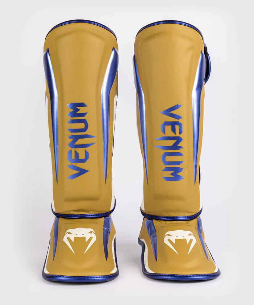 Paratibie Venum Elite Camel e Blu realizzati a mano in Thailandia garantiscono protezione e comfort di livello professionale per i tuoi allenamenti di Muay Thai, MMA e Kickboxing. Design avvolgente e ultraleggero per la massima mobilità.