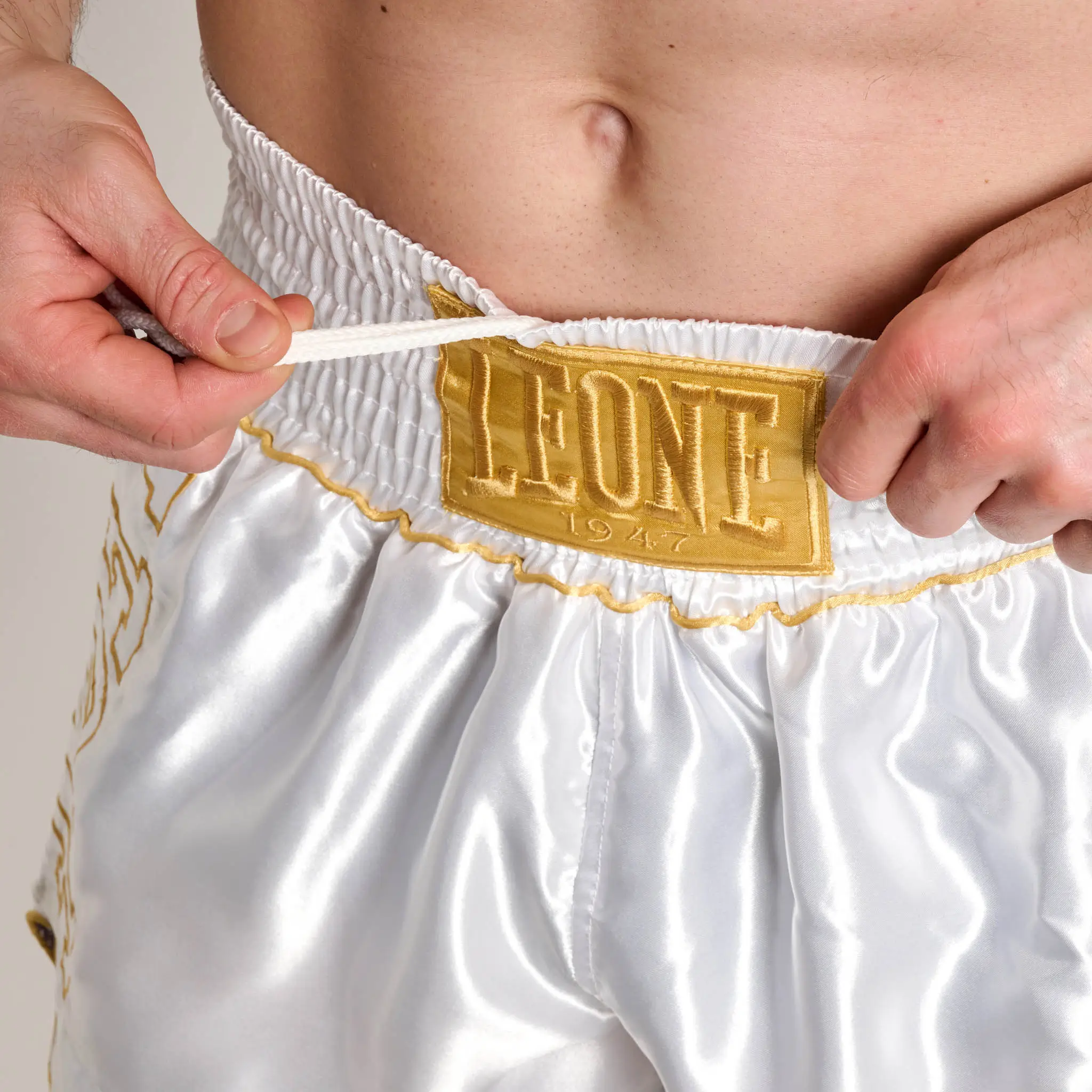 Pantaloncini Leone 1947 DNA Premium AB969 Bianco/Oro per allenamenti e match di Kickboxing e Muay Thai. Nuova collezione Leone 1947