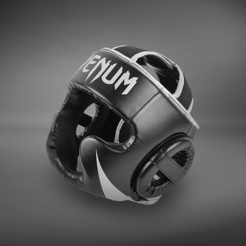 Caschetto Venum Challenger Nero/Silver VENUM-2052-128 per allenamenti e sparring di Muay Thai, Boxe, Kickboxing ed MMA. Caschetto allenamento basic con parazigoni e paramento.
