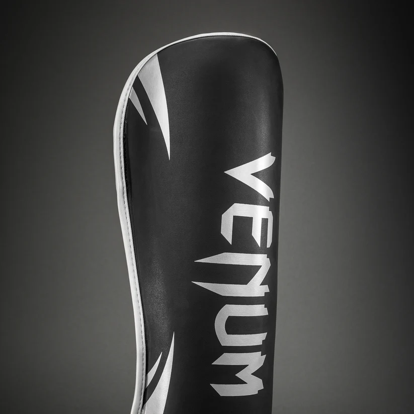 Paratibie Venum Chllenger Nero/Silver VENUM-2050-128 per allenameti di Muy Thai, kickboxing ed MMA. Paratibie strutturato da allenamento con chiusura in velcro stabile e solido, Paratibie principianti.