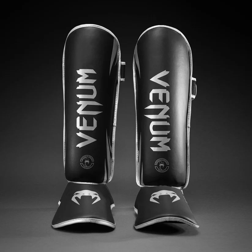 Paratibie Venum Chllenger Nero/Silver VENUM-2050-128 per allenameti di Muy Thai, kickboxing ed MMA. Paratibie strutturato da allenamento con chiusura in velcro stabile e solido, Paratibie principianti.